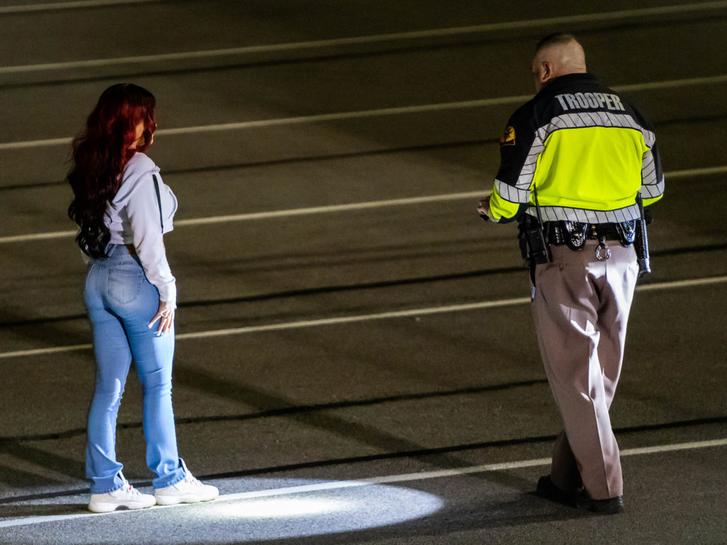 A UHP trooper observes as a female performs the heel toe walk as part of a sobriety test.