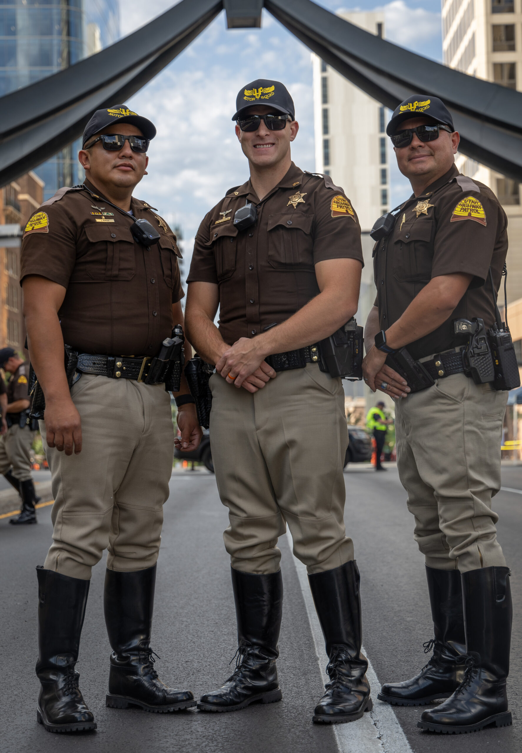 Three motor troopers standing under the Eagle Gate Monument in Salt Lake City