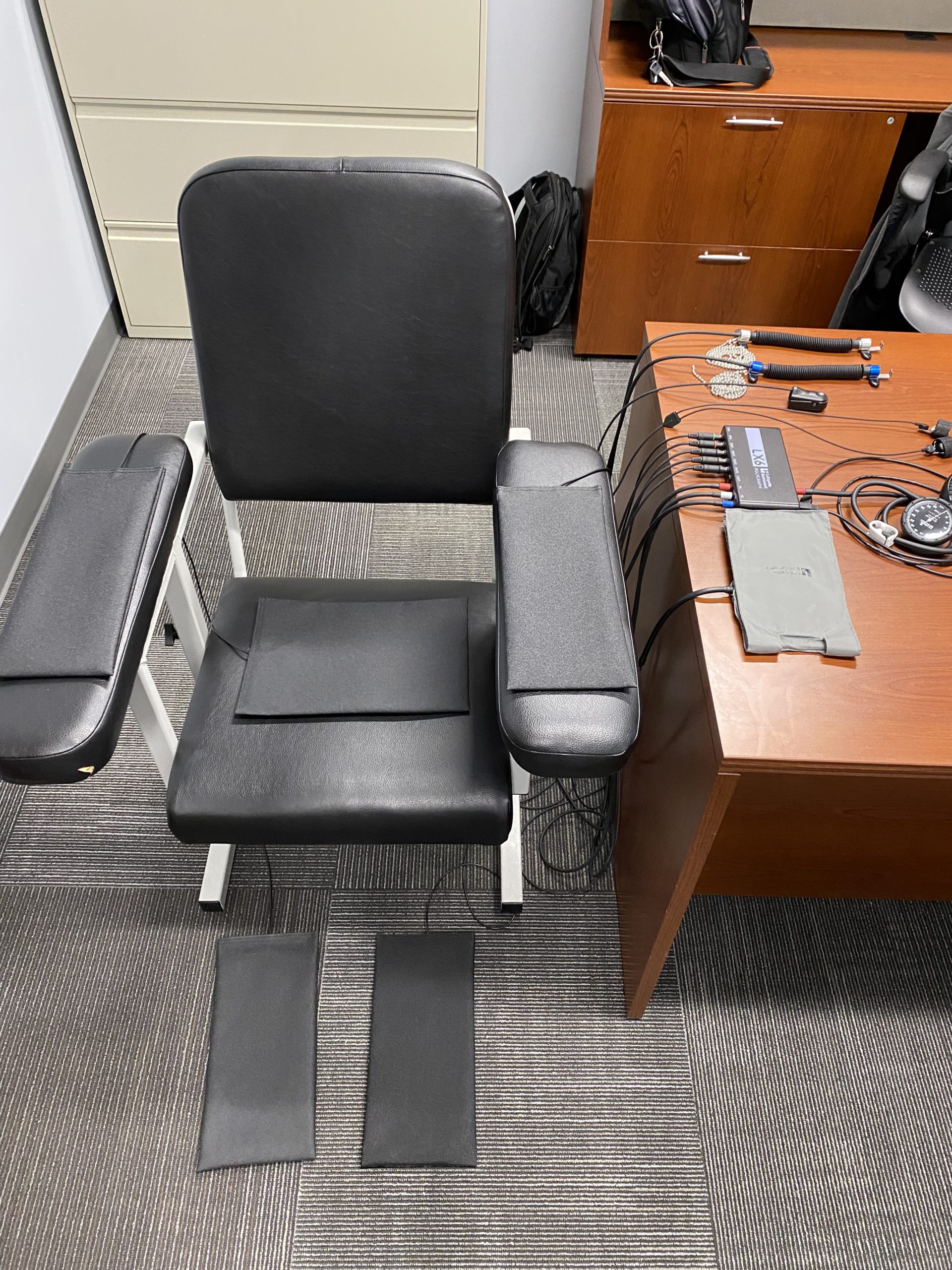 Chair with polygraph equipment around and on it.