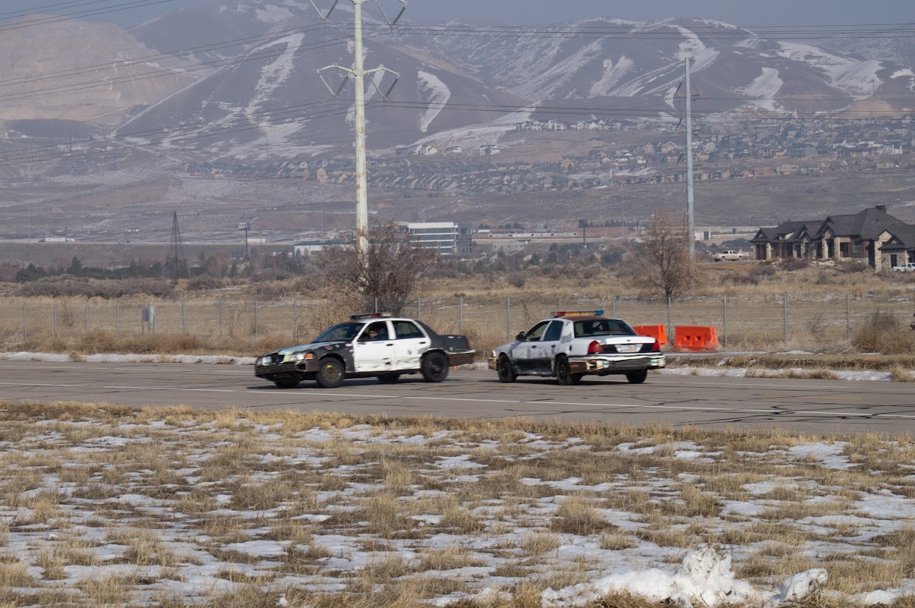 Two crown victorias are shown during a PIT maneuver training at the EVO track.