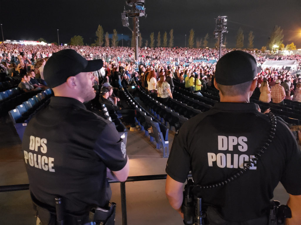 Two members of the SBI alcohol enforcement team stand on the edge of the seating area at a concert.