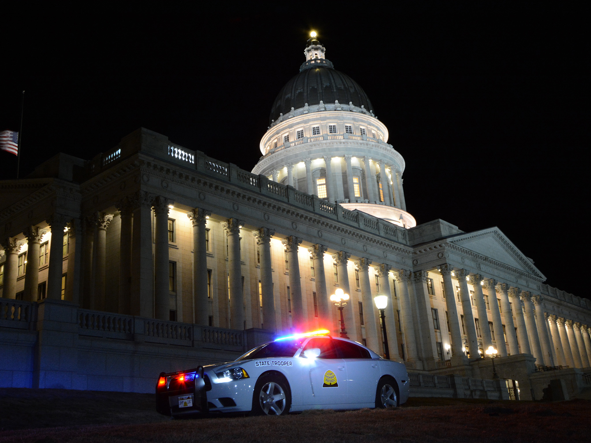 A UHP charger is parked in front of the state capitol building at night.